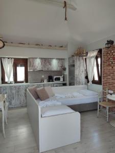 a living room with a white couch and a kitchen at VILLA KALDERA in Skiathos Town
