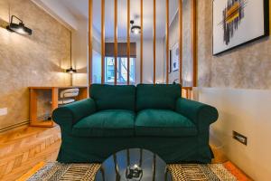 a living room with a green couch and a table at Designer Central Getaway in Cluj-Napoca