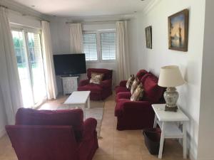 ein Wohnzimmer mit 2 Sofas und einem TV in der Unterkunft La Castañera in Cabezón de la Sal