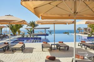 a resort with a pool and tables and umbrellas at Dreams Lanzarote Playa Dorada Resort & Spa in Playa Blanca