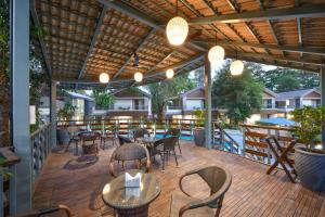 a patio with tables and chairs on a deck at Arova Woods Zinc Journey by The Fern, Lonavala in Lonavala