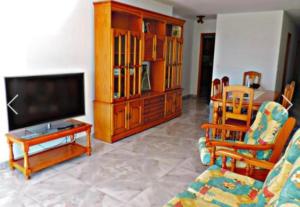 a living room with a flat screen tv and chairs at Apartamento El Tejar in Tazacorte