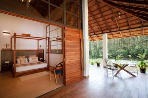 een slaapkamer met een bed en een tafel in een kamer bij StayVista at Cedar @ Strelitzia in Chikmagalur