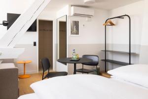 Fred Hotel Zürich Hauptbahnhof في زيورخ: غرفه بطاوله وكراسي ودرج