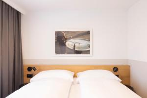 a bedroom with two beds and a picture on the wall at Fred Hotel Hauptbahnhof in Zurich