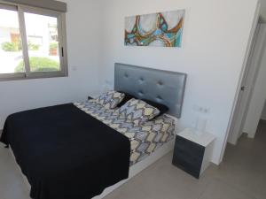 ein Schlafzimmer mit einem schwarzen Bett und einem Fenster in der Unterkunft Villa Chopin La Marina in San Fulgencio