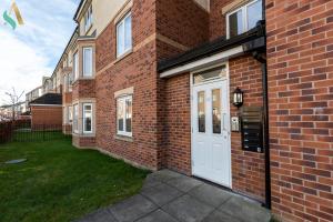 a brick building with a white door on it at Mulberry Wynd TSAC in Stockton-on-Tees