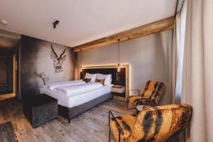 een slaapkamer met een bed met een hertenkop aan de muur bij ALTE POST Gastein - Alpine Boutique Hotel & Spa in Bad Hofgastein