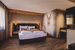 a bedroom with a bed with a deer head on the wall at ALTE POST Gastein - Alpine Boutique Hotel & Spa in Bad Hofgastein