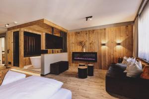 a bedroom with a bed and a tv and a fireplace at ALTE POST Gastein - Alpine Boutique Hotel & Spa in Bad Hofgastein