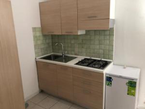 a kitchen with a sink and a stove and a refrigerator at Villaggio Santo Stefano in Vieste