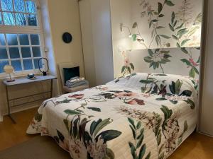 a bedroom with a bed with a floral comforter at Apartment Pont Romain in Vaison-la-Romaine +50 photos