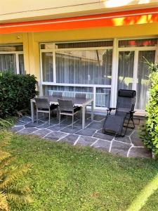 eine Terrasse mit einem Tisch und Stühlen auf einem Haus in der Unterkunft Sibylle in Locarno