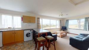 een keuken en een woonkamer met een wasmachine en droger bij D56 Beachcomber, Riviere Towans in Hayle
