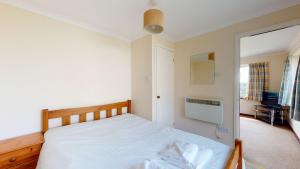 een slaapkamer met een bed en een deur naar een kamer bij D56 Beachcomber, Riviere Towans in Hayle