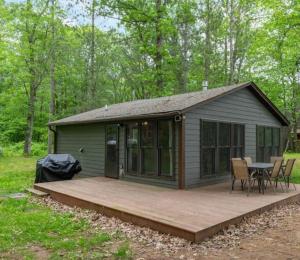 a cabin with a wooden deck in the woods at $99 midweek-2 bedroom-Riverfront-Fireplace- Pet ok in Pine City