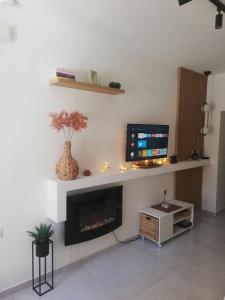 a living room with a tv and a fireplace at BRIO luxurious urban stay in Heraklio,WiFi,ΑC in Heraklio Town