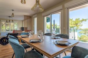 uma sala de jantar com uma mesa de madeira e cadeiras em O'DUNE Pyla Plage -appartement jacuzzi vue mer - em Pyla Sur Mer