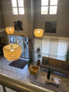 a living room with a couch and tables and windows at Kyriad Hotel Montpellier Centre Antigone in Montpellier