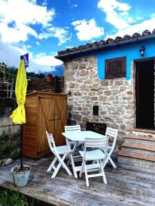 a white table and chairs on a wooden deck at Cabaña de Piedra en Picos de Europa in Arenas de Cabrales