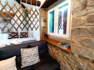 Habitación con sofá y pared de piedra. en Cabaña de Piedra en Picos de Europa en Arenas de Cabrales