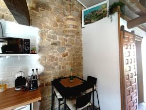 una pequeña mesa en una cocina con una pared de piedra en Cabaña de Piedra en Picos de Europa, en Arenas de Cabrales