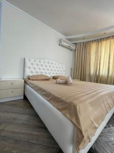 a bedroom with a large bed with a stuffed animal on it at Family apartment 7 in Shymkent