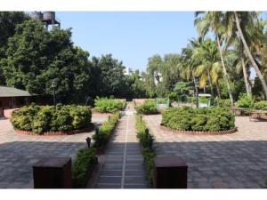 a pathway in a park with bushes and trees at Nilambag Palace Hotel in Bhavnagar