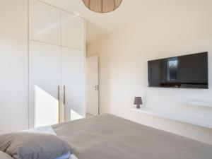 a bedroom with a bed and a tv on a wall at Calmaliving Seaside apartments with pool in Gerani Chanion