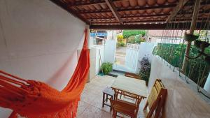 Un porche con una hamaca en un patio. en Casinha Guajiru, en Trairi
