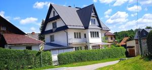 duży biały dom z czarnym dachem w obiekcie Królówka w mieście Maków Podhalański