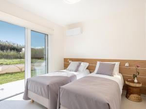 two beds in a room with a large window at Calmaliving Seaside apartments with pool in Gerani Chanion