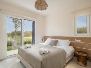 sypialnia z dużym łóżkiem z dwoma ręcznikami w obiekcie Calmaliving Seaside apartments with pool w mieście Gerani