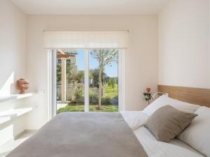 a bedroom with a bed and a large window at Calmaliving Seaside apartments with pool in Gerani Chanion