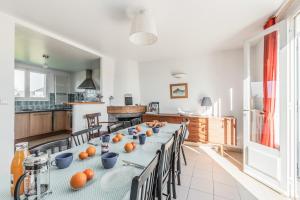 a large kitchen with a long table with chairs at Ker Kast - Grande maison proche plage in Saint-Cast-le-Guildo