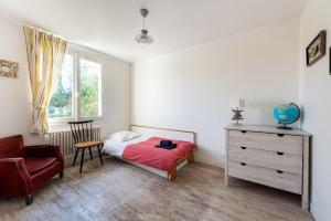 a bedroom with a bed and a chair and a dresser at Ker Kast - Grande maison proche plage in Saint-Cast-le-Guildo