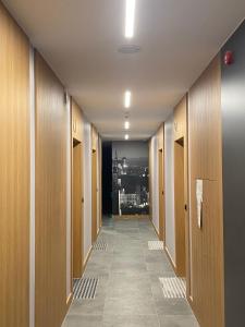 a corridor of a hallway with wooden doors and a tile floor at Apartament Gdańsk Śródmieście Wałowa in Gdańsk