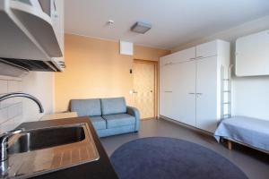 Hostel Teopolis في تامبير: مطبخ وغرفة معيشة مع أريكة ومغسلة