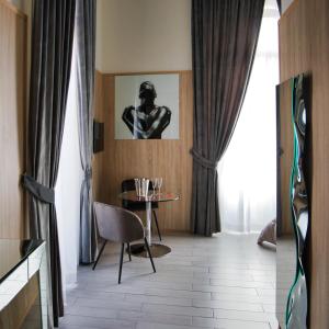 a room with a table and a picture of a man at Kore Luxury Suite e Spa in Naples