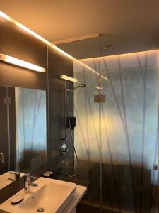 a bathroom with a sink and a shower with a mirror at LOGIS125 I Barbara Hofmann in Gamlitz