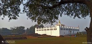 duży biały budynek z wieżą w parku w obiekcie The Lumbini Village Lodge w mieście Rummindei
