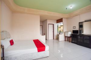 - une chambre avec un lit et une télévision dans l'établissement RedDoorz @ Jalan Jendral Sudirman Jambi 2, à Palmerah