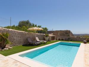 a swimming pool with two chairs and an umbrella at Casa del Sol in Búger