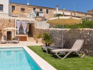 a pool with two lounge chairs and an umbrella at Casa del Sol in Búger