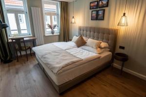 een groot bed in een slaapkamer met 2 ramen bij Ferienwohnung Rathausblick 1 mit Infrarot-Kabine in Blankenburg