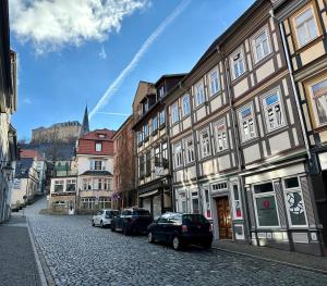 een straat met gebouwen en auto's op straat bij Ferienwohnung Rathausblick 1 mit Infrarot-Kabine in Blankenburg