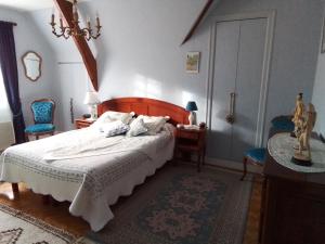 um quarto com uma cama e duas cadeiras azuis em Villa Garnier em Saint-Michel-sur-Loire