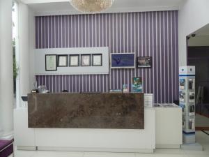 a counter in a room with a purple stripped wall at Vio Surapati Bandung in Bandung