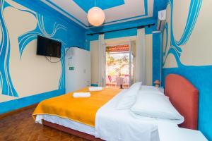 niebieski pokój z łóżkiem i telewizorem w obiekcie Apartments Jelka w mieście Jelsa