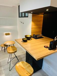 cocina con encimera de madera y 2 taburetes en Feel@Home Nemausus « Le 42 », en Nimes